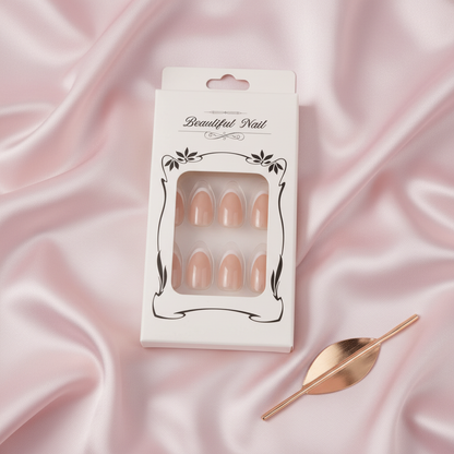 Packaged nude press-on nail set styled on blush satin